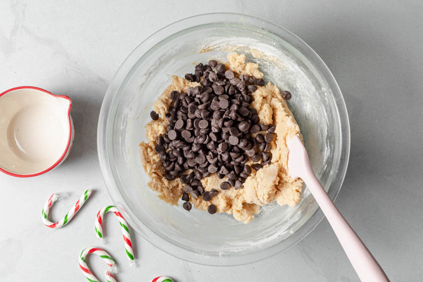 Chocolate chips and candy canes added to bowl