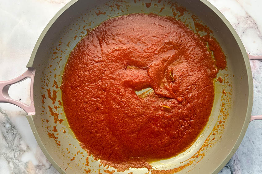 Strained tomatoes added to pan