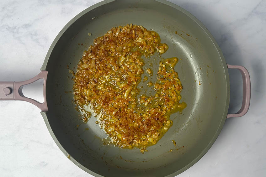 Minced garlic and onions cooking in pan