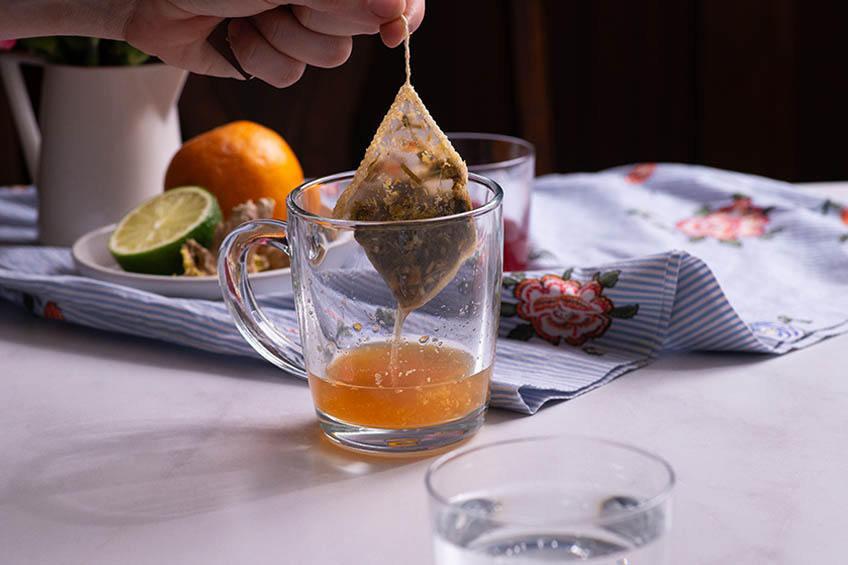 Tea bag being removed from mug