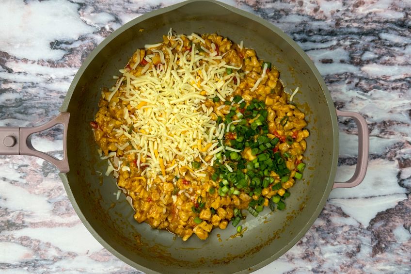 Cheese and green onions added to skillet