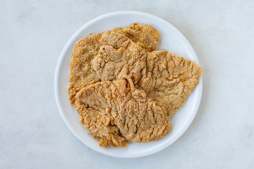 Uncooked, breaded schnitzel on a plate