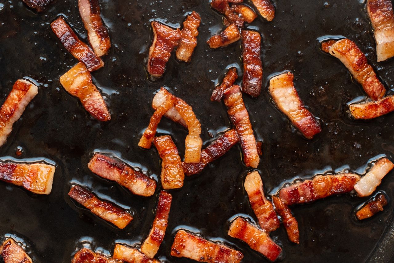 Pancetta cooking on a stovetop