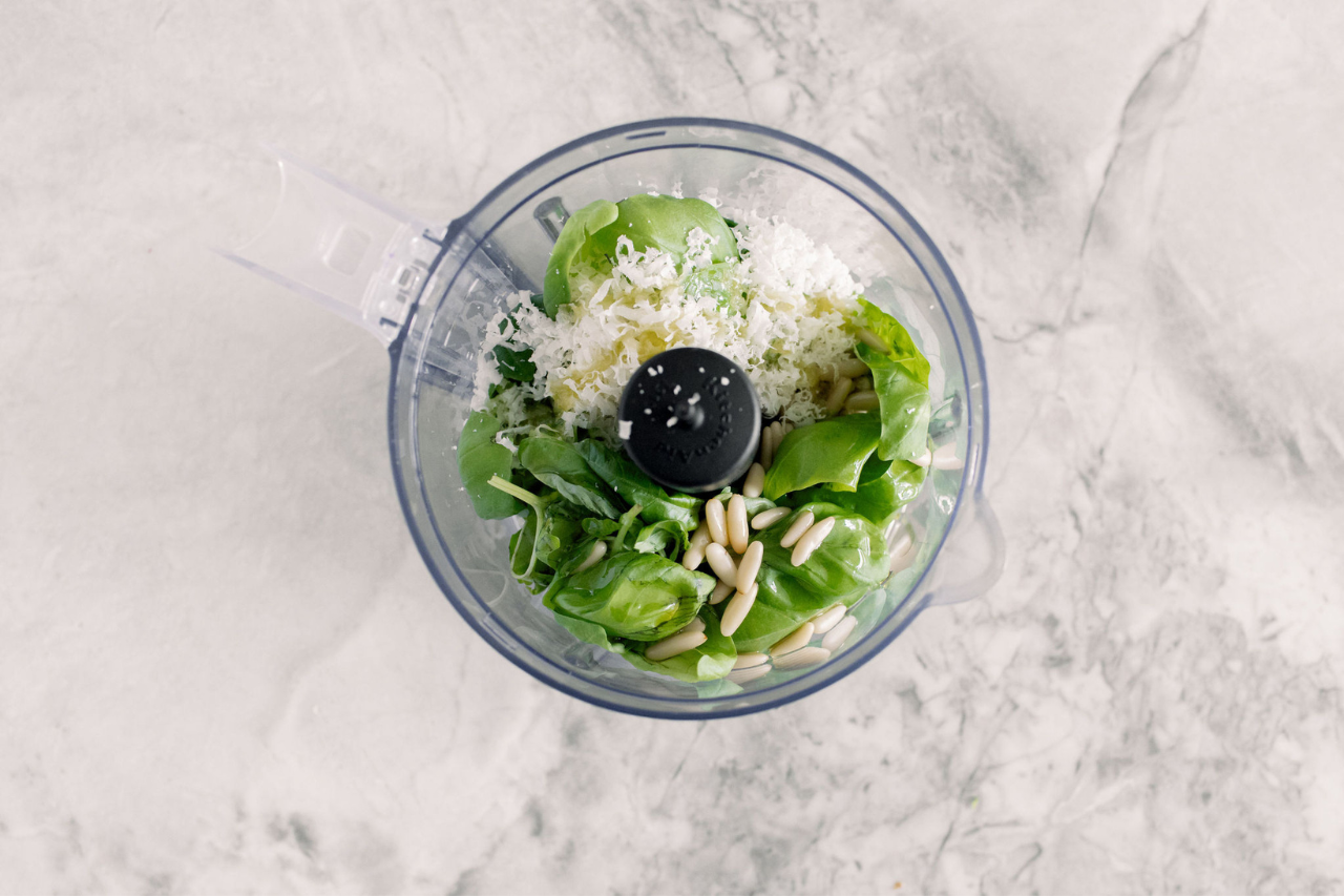 Ingredients of a homemade pesto in a food processor.