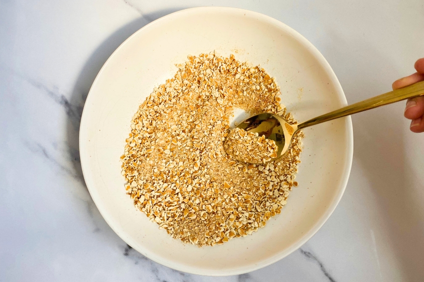 Pretzel coating in a bowl with a gold spoon