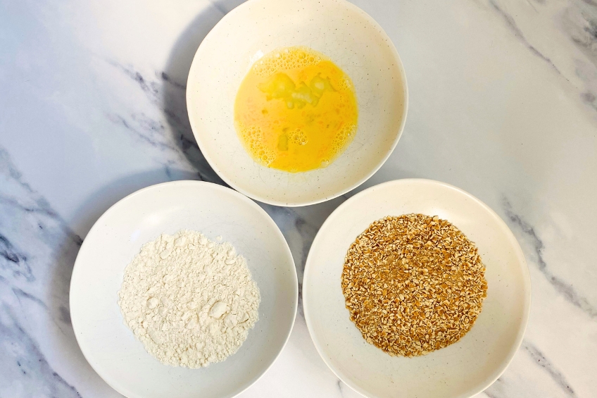 Egg wash, flour and pretzel seasoning in three separate bowls