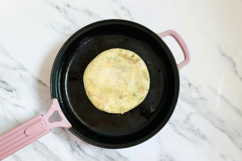 Face down smash dumpling taco in a skillet