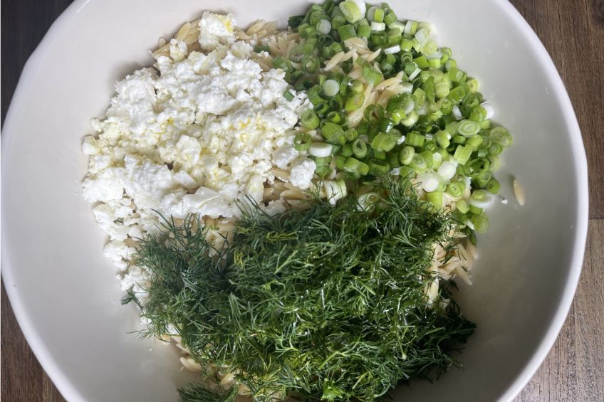 greek pasta salad ingredients right before being mixed in a large bowl