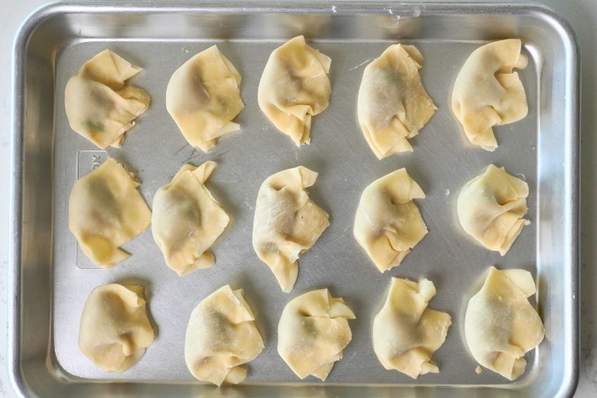 shrimp dumplings assembled on a sheet pan before being fried