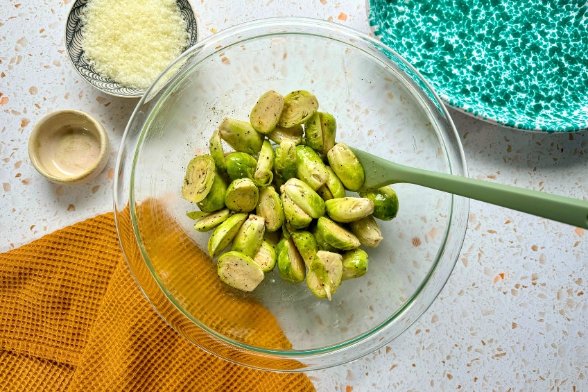 Brussels sprouts in a mixing bowl tossed with butter, salt and pepper