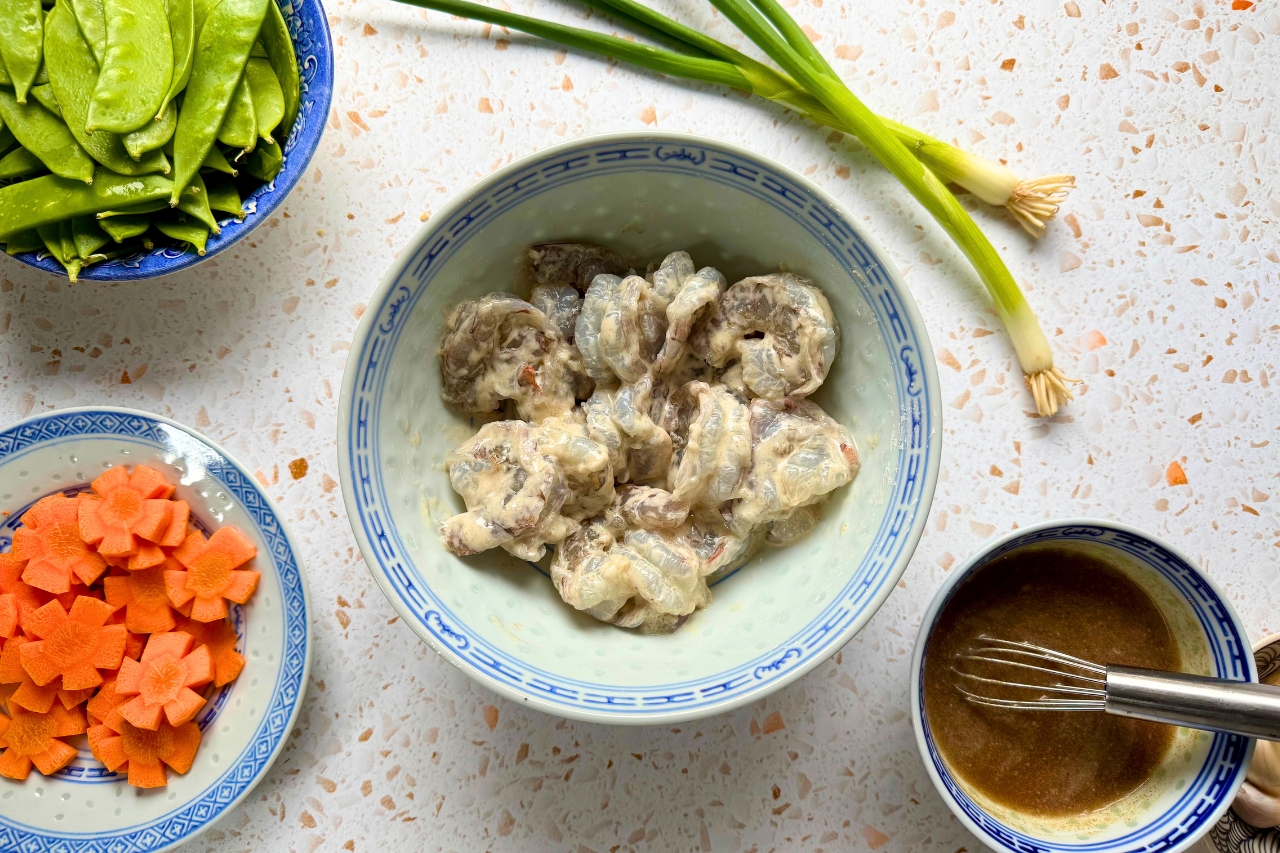 Shrimp coated in cornstarch and seasoning in a bowl