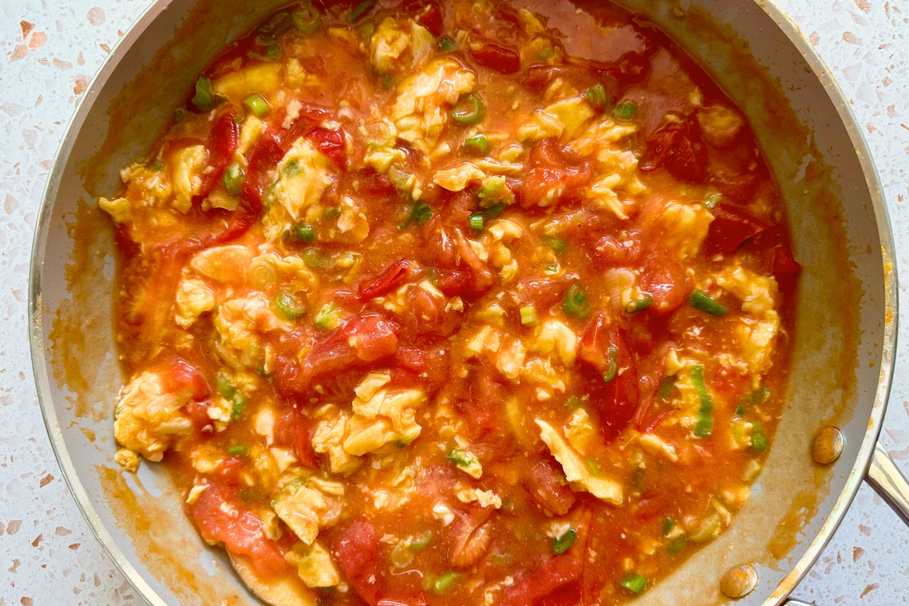Closeup on Chinese stir fried tomato eggs in frying pan