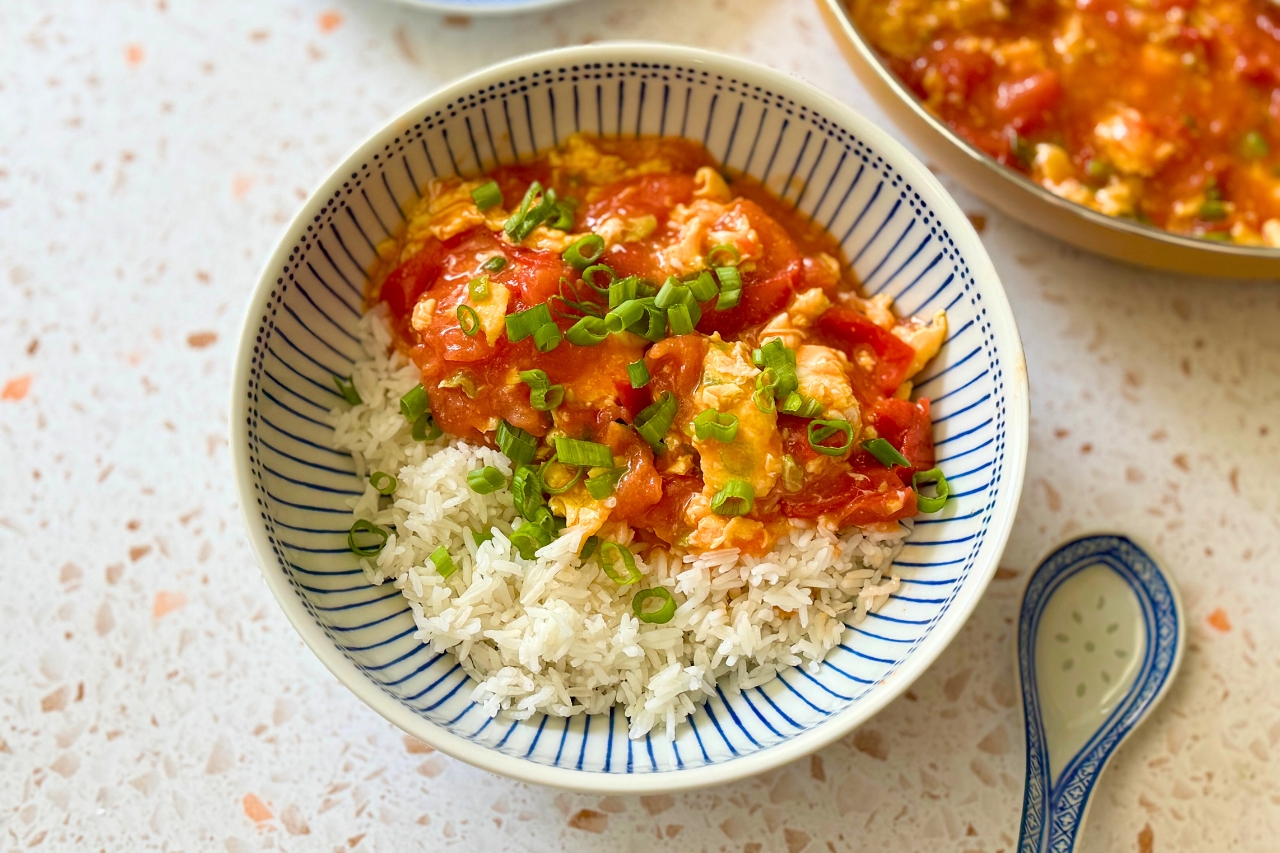 Chinese tomato egg stir fry over rice in a bowl